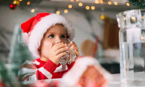 Kid drinking water from tap on Christmas
