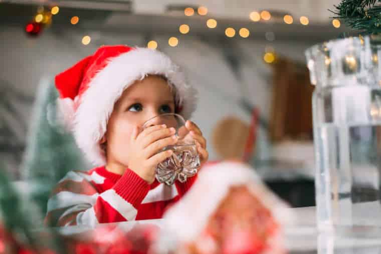 Kid drinking water from tap on Christmas
