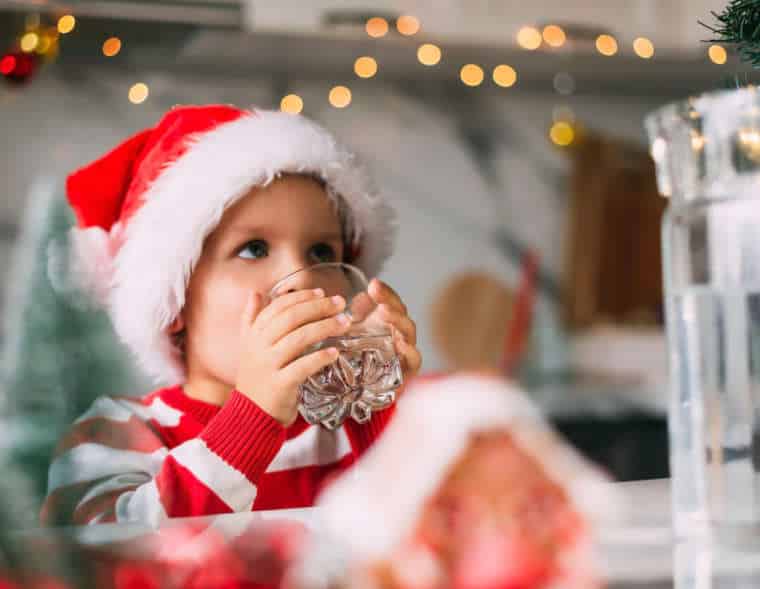 Kid drinking water from tap on Christmas