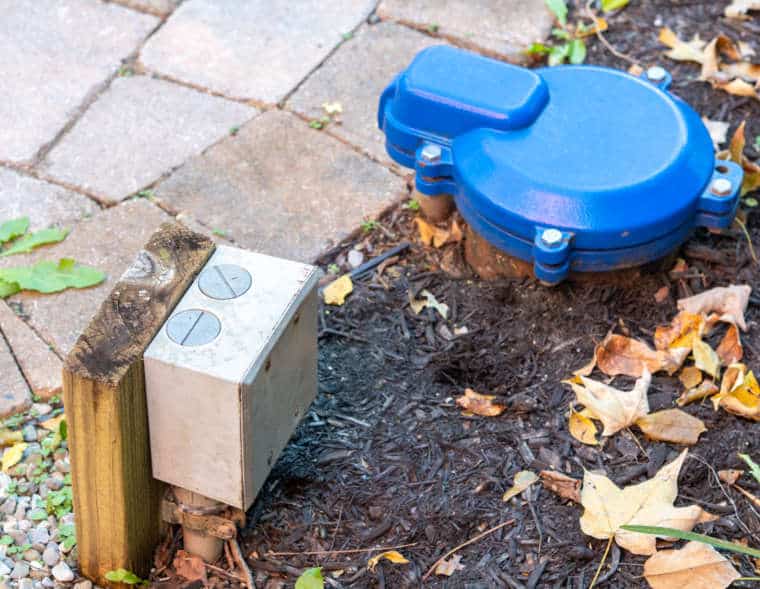 outside feature of a well pump with blue cover and electric outlet