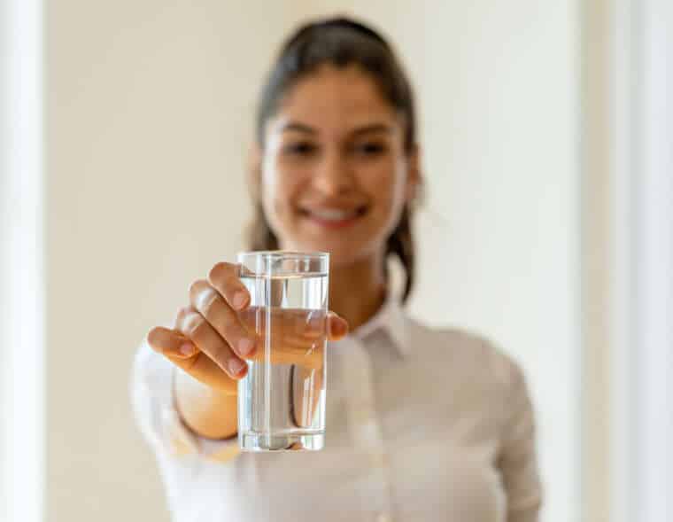 Young girl holding glass of water