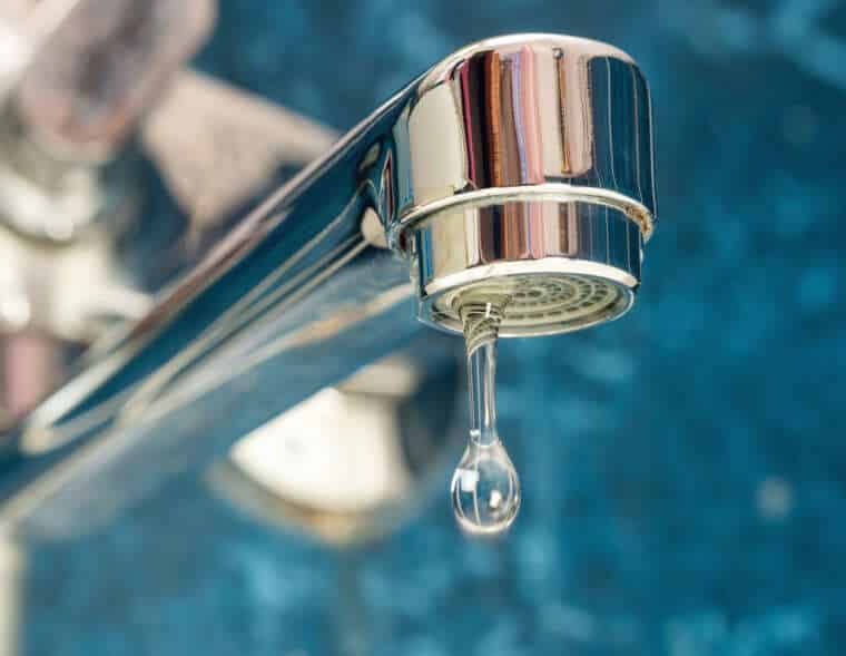 A drop of water drips from a leaky faucet