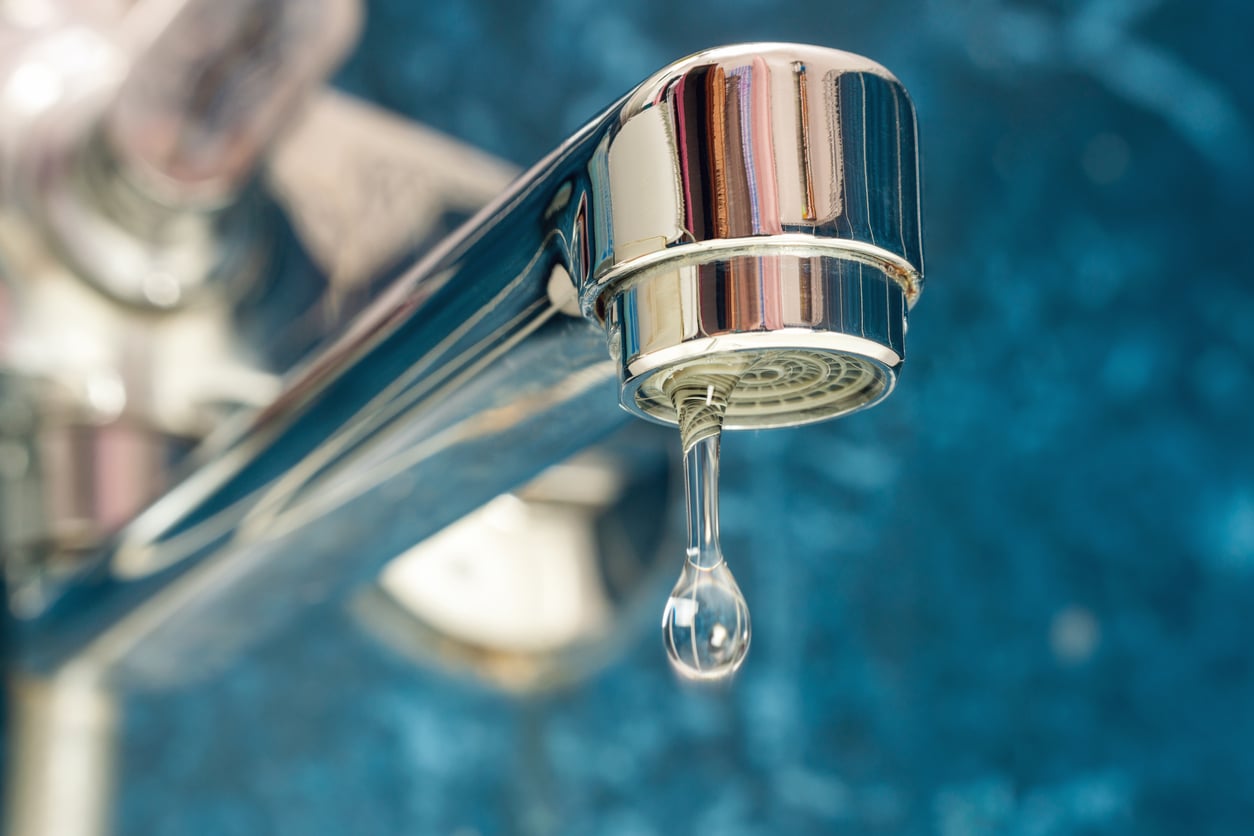 A drop of water drips from a leaky faucet