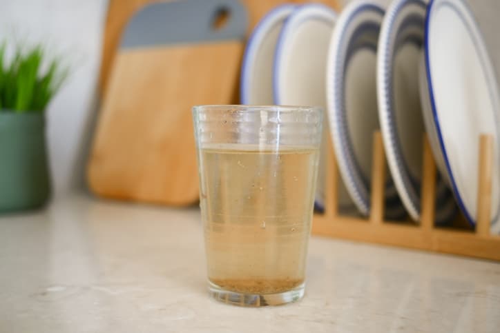 dirty glass of water on kitchen table .