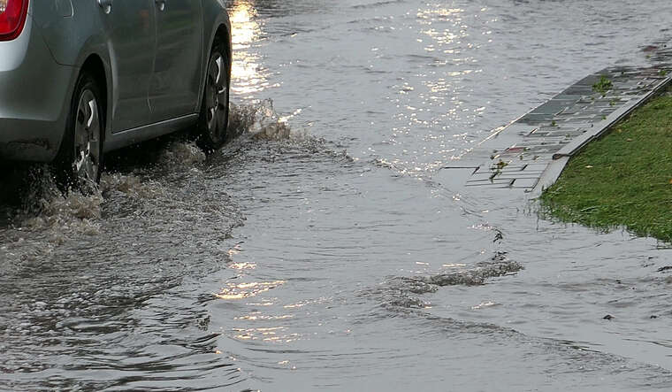 Cars Crossing Flooded Urban Street