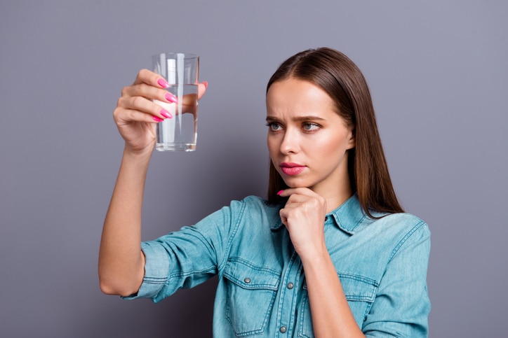 Close up portrait of not sure in quality of water she her woman girl wearing casual jeans shirt outfit clothes isolated on grey background